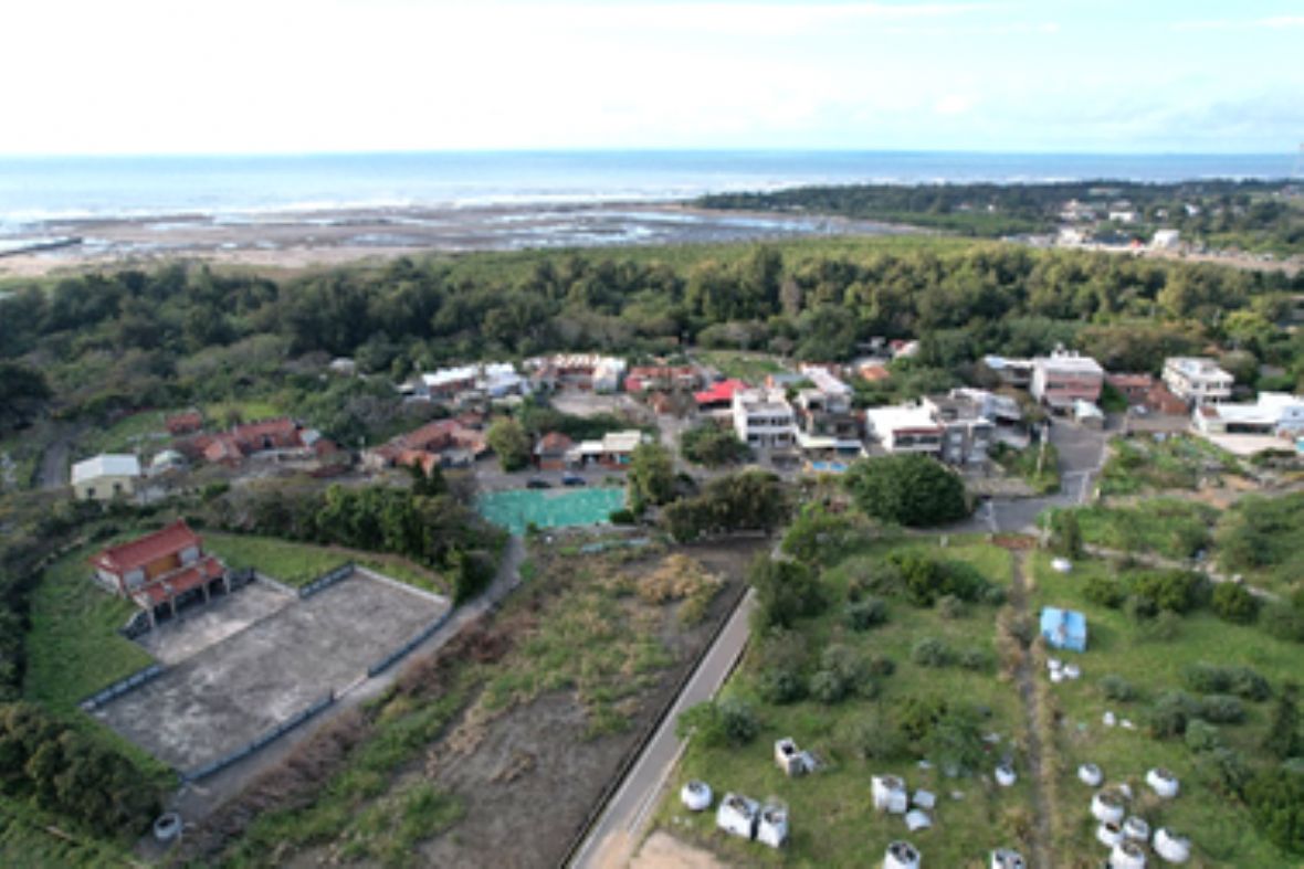 姜厝聚落位於海濱沙丘面向內陸一側，左下角可見祖塔