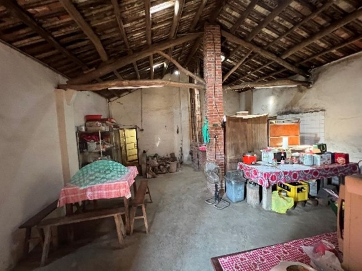 灶爐在紅磚柱後面；柱前靠左牆壁，擺有方形飯桌、長板凳；飯廳與廚房相鄰配置。