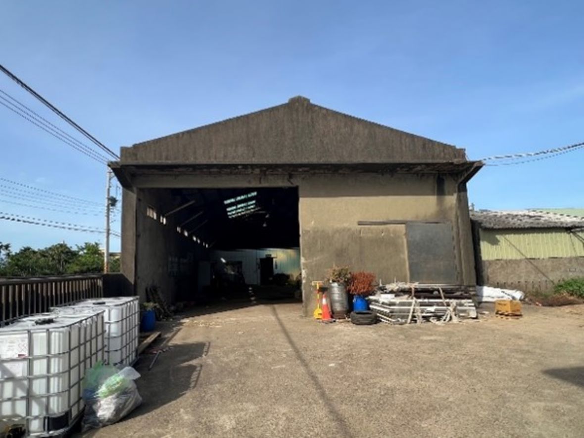  合成牧場飼料倉庫正立面。出入口大小佔去山牆面的一半，但是出入口上R.C.造出簷伸展至全山牆面寬幅大小。