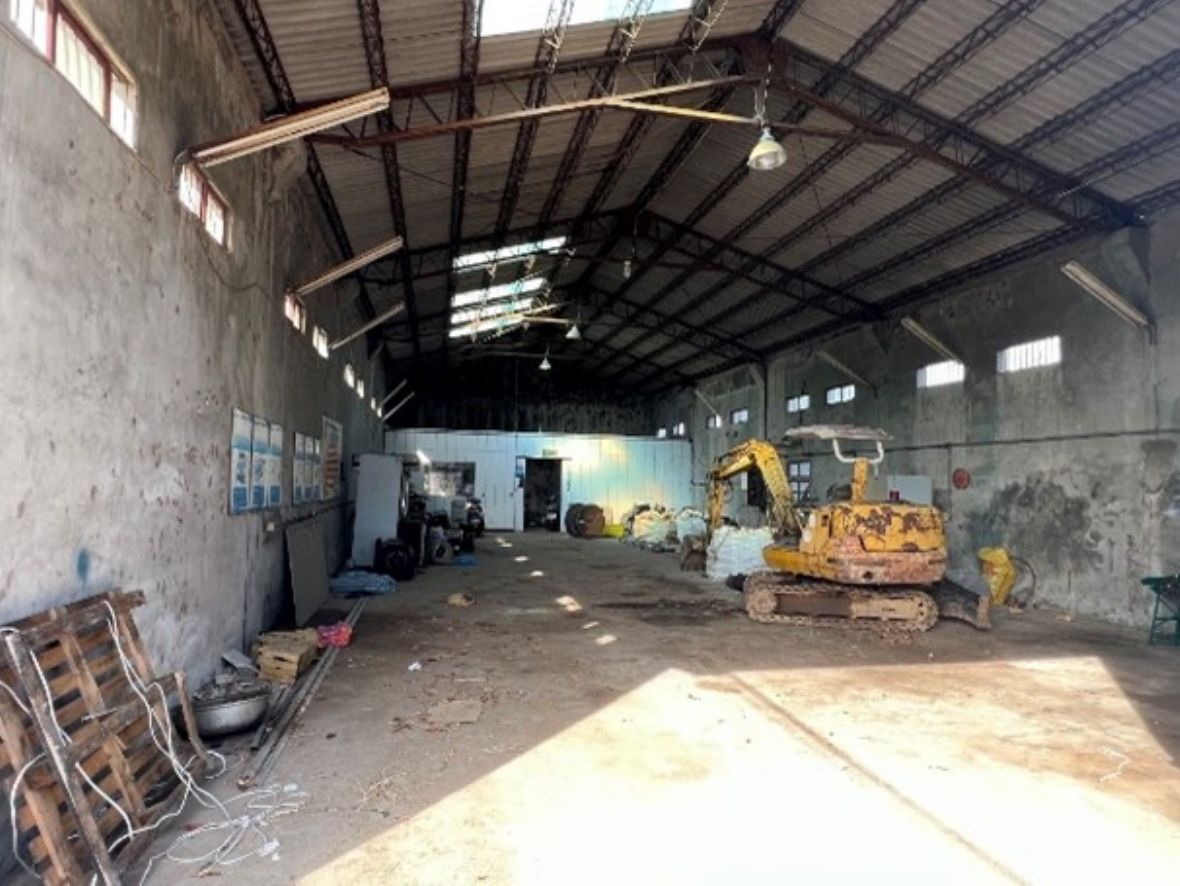 合成牧場飼料倉庫內部。內部空間為一完整的大空間，可以從內部觀看到位於高牆上整齊的左右兩列高窗。屋頂為現代工業建材之鐵製桁架結構支撐，屋頂面鋪水泥浪版。已經有許久不用作飼料倉庫了。