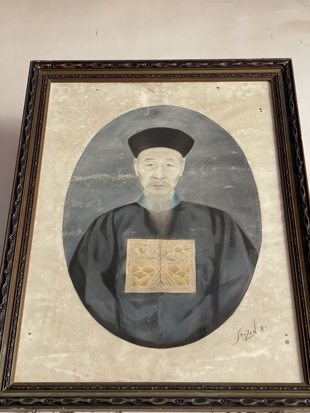 騰清公像身著藍圓領石青色朝服，上繪一品文官仙鶴方補，戴暖帽