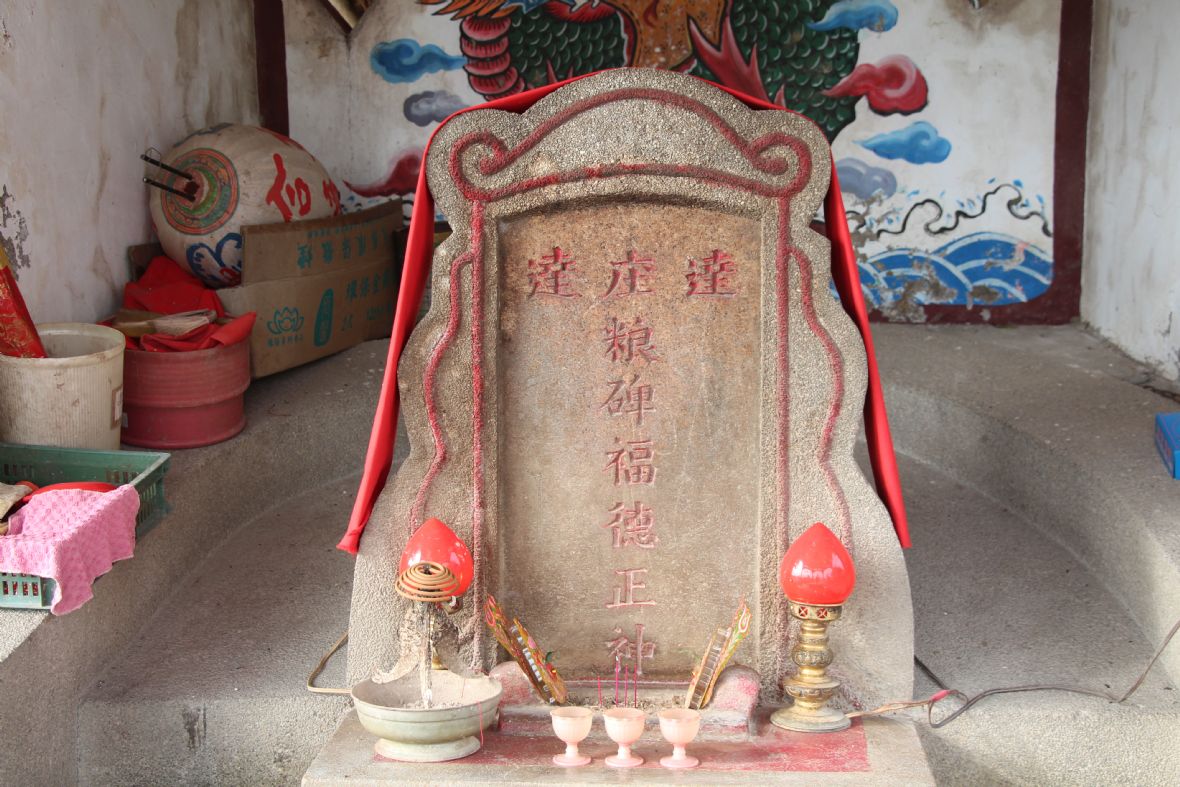 石碑神位上披有紅絲絨，並陰刻書寫「達達庄粮埤福德正神」