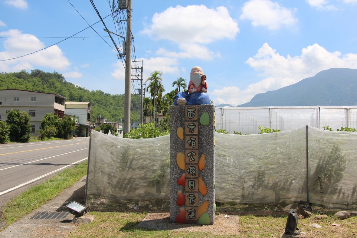 左側出口處立有「西方伯公假日市集」石柱。