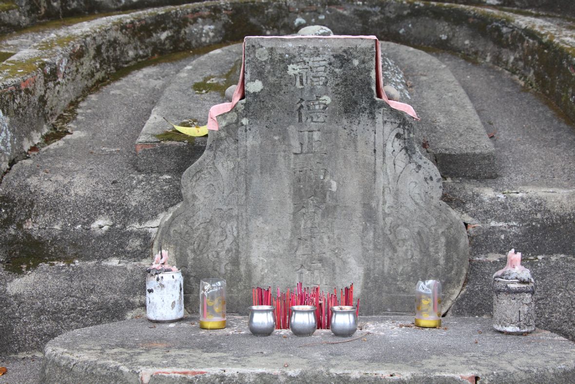 典型的客家「風水式伯公壇」（又稱墓塚式），主體為水泥磚砌構造，神位石碑披覆紅絲絨，陰刻「福德正神香座位」，兩側碑耳為葫蘆形，雕有草捲圖樣，形制類似葫蘆，象徵「福氣盈門」。 曲手（即墓耳）呈雙層設計，內層刻字雖已模糊，仍可辨識其原貌。