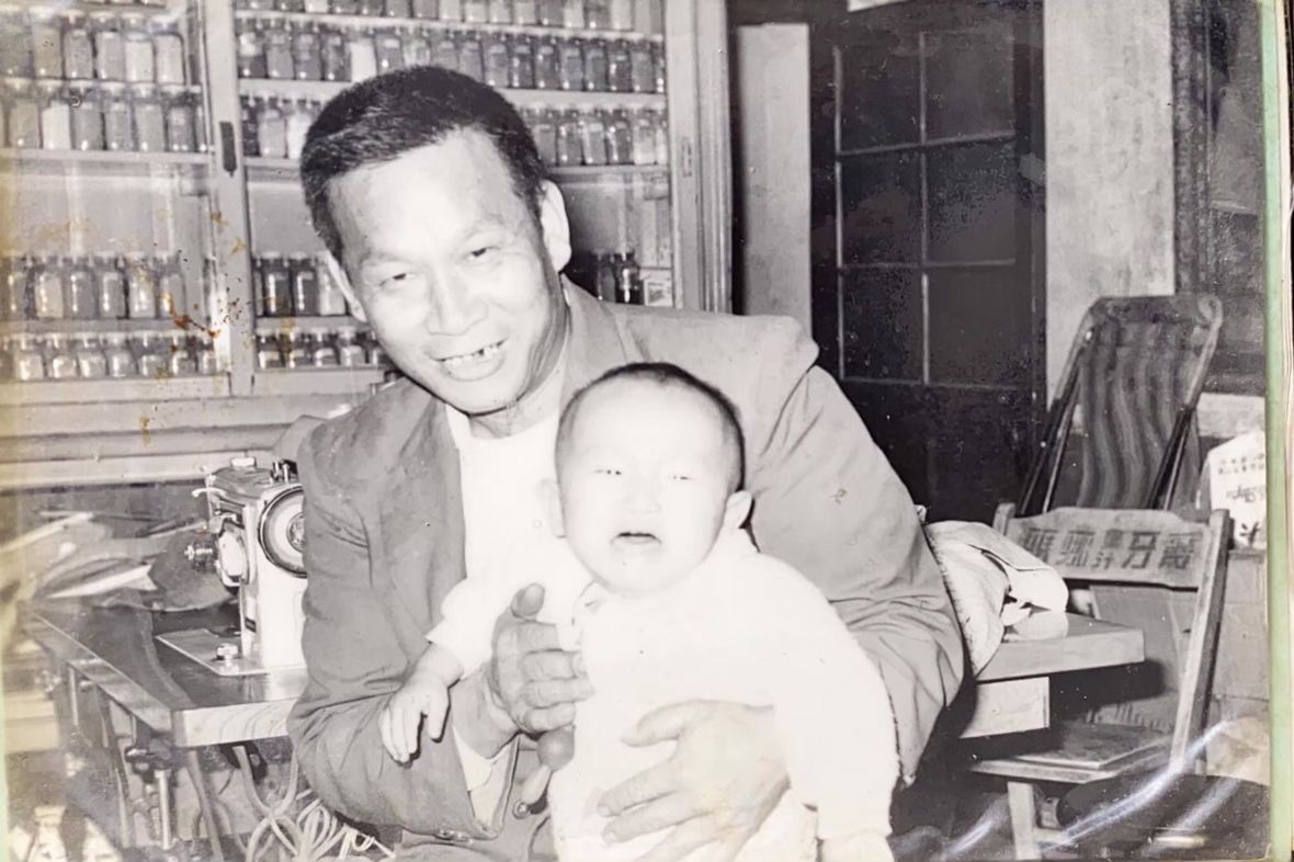 12.賴雙喜在新回春藥房抱孫子合影。賴逢彰/提供