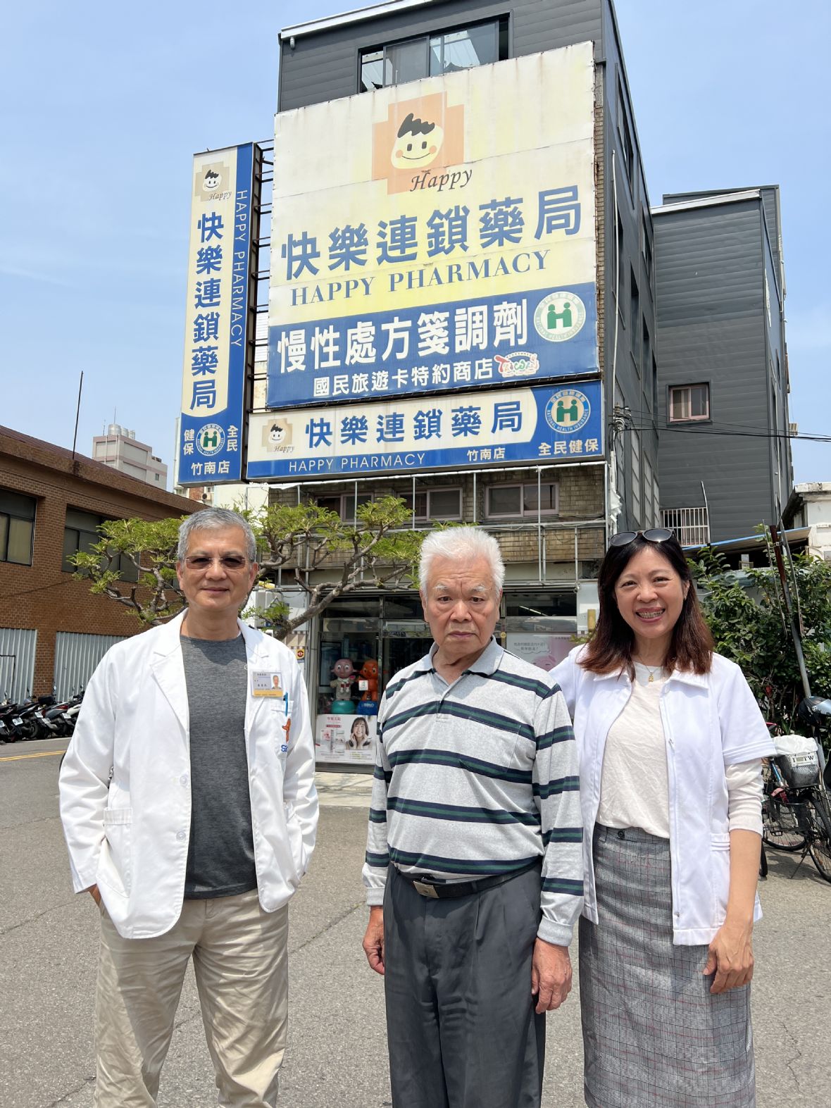 24. 新生堂第二代?成邦（中）與第三代?惠民（左）及妻子陳俐孜在快樂藥局前合影。
