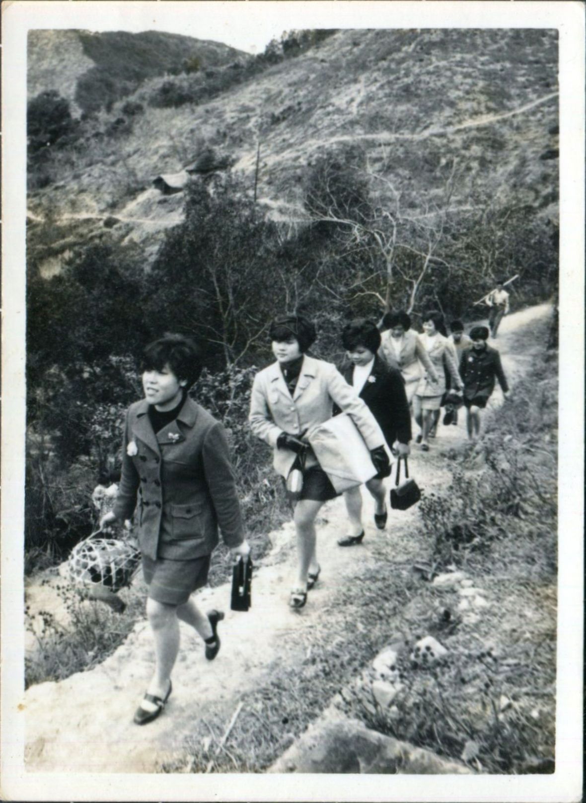 14. 邱瑞英手提帶路雞，與同事們步行在三灣員林的山路上，準備前往造橋大坪新郎家中。