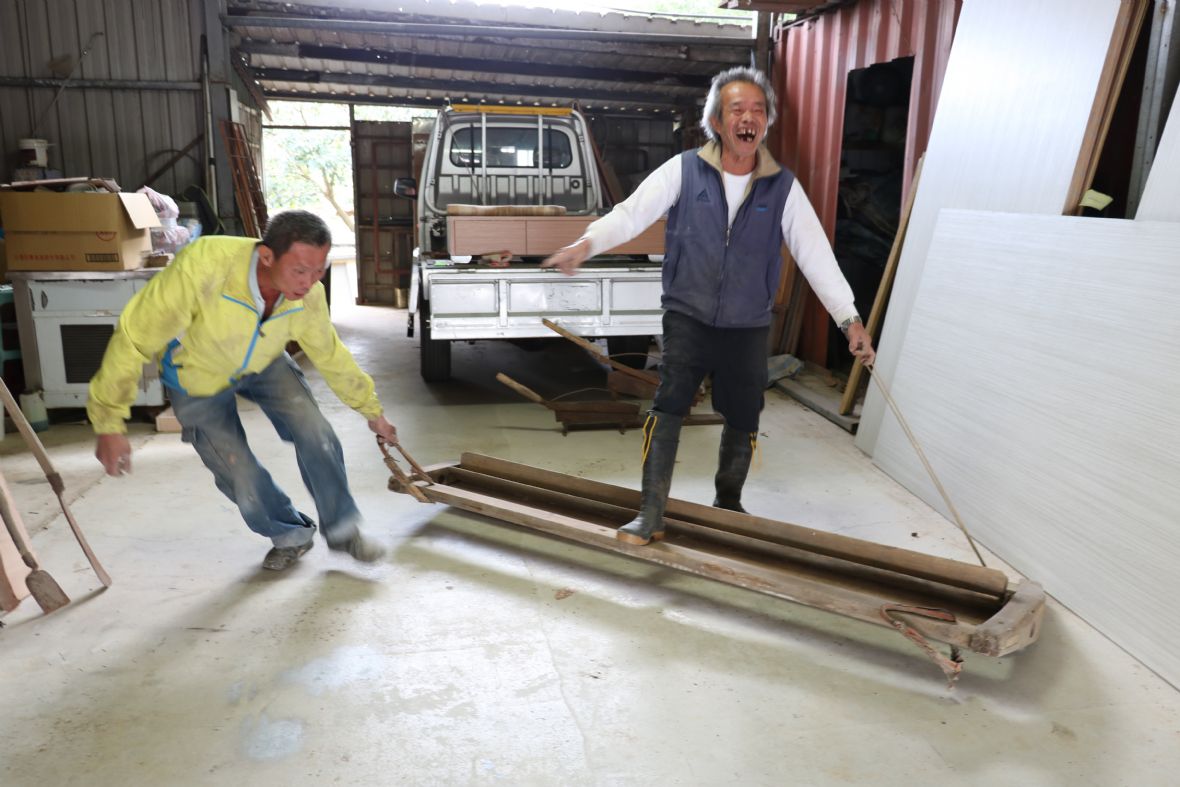 何啟鏞（圖右）與鄰居（圖左）的碌碡操作示範