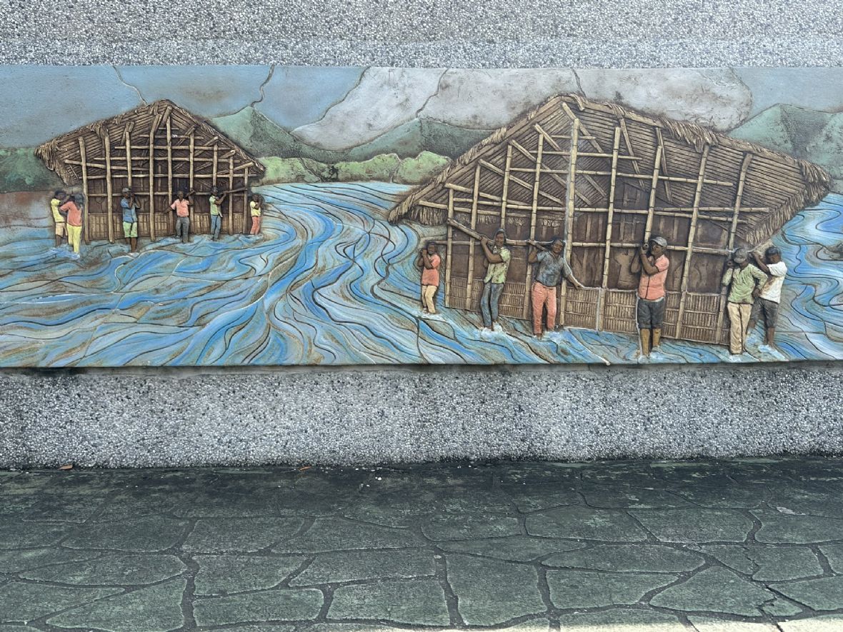 陶板壁畫描繪客家先民扛屋過溪遷徙的歷史場景（傅立誠攝，2024）